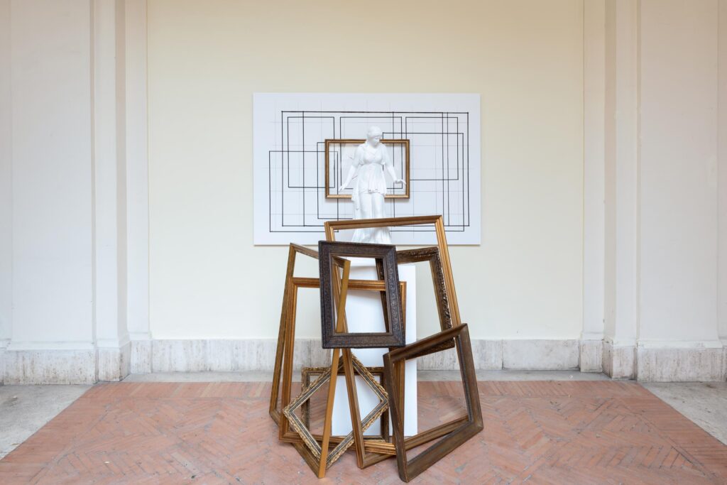 immagine per Giulio Paolini In cornice, 2023 Calco in gesso, base bianca, cornice su pannello fotografico, cornici dorate. Calco in gesso h 87 cm, base 100 × 50 × 50 cm, pannello fotografico 120 × 180 cm, cornici dorate di varie dimensioni, misure complessive variabili. Foto Andrea Veneri