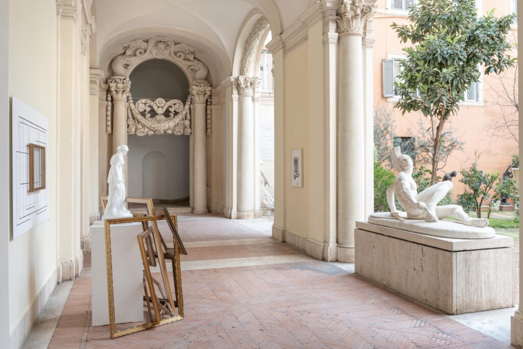 immagine per Giulio Paolini In cornice, 2023 Calco in gesso, base bianca, cornice su pannello fotografico, cornici dorate. Calco in gesso h 87 cm, base 100 × 50 × 50 cm, pannello fotografico 120 × 180 cm, cornici dorate di varie dimensioni, misure complessive variabili. Foto Andrea Veneri