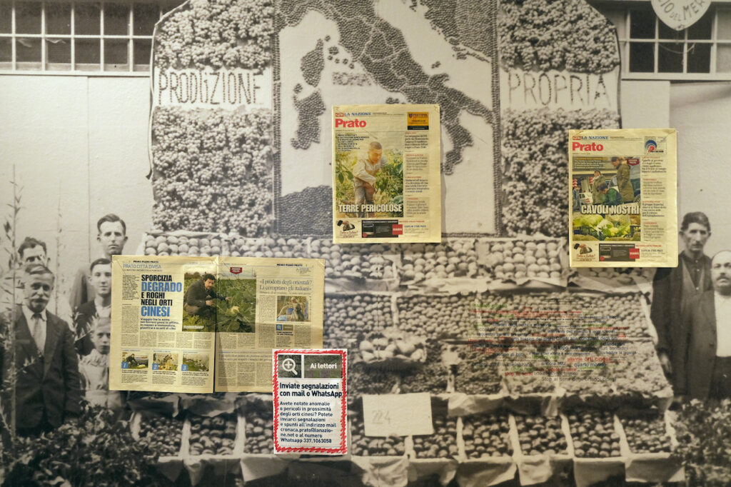 immagine per Leone Contini, Produzione propria, 2022 (Prato) (dettaglio), macerie, cassette di frutta, pagine di giornali, cloud testuale, immagine di archivio / rubble, fruit crates, newspaper pages, text cloud, archive image (Stand ortofrutticolo della ditta G. Magni e Figlio in piazza Lippi a Prato, 1931 © Comune di Prato - Archivio Fotografico Toscano-Fondo ADT, imm Ap1 p53), installazione, dimensioni ambiente / installation, room-size, Courtesy l’artista