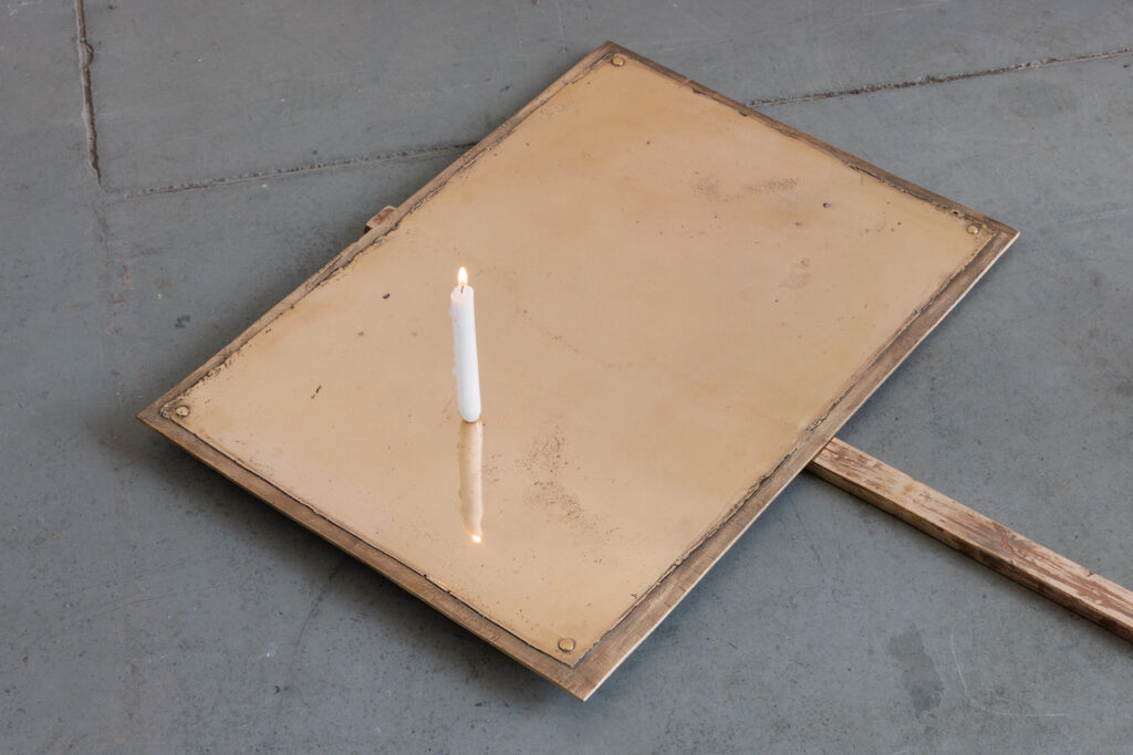 immagine per Cartello, 2023 Bronzo, candela; cm 73x180x3 Cartello è la rappresentazione di un cartello da manifestazione, uno di quelli che solitamente sono composti da un cartello d forma quadrata o rettangolare attaccato a un’asta così che si possa tenerlo con le mani e sollevarlo in alto. Questo cartello non ha una derivazione specifica, è uno dei tanti, potrebbe venire da una foto di uno sciopero degli anni 20 del secolo passato così come essere uno dei cartelli che utilizzano gli adolescenti di oggi nelle loro manifestazioni per la tutela dell’ambiente. Sul cartello non c’è scritto nulla, è poggiato a terra, dove dovrebbe esserci la frase per la quale è stato costruito e di cui sarebbe supporto c’è una candela accesa che spande la sua cera sulla superficie del cartello.