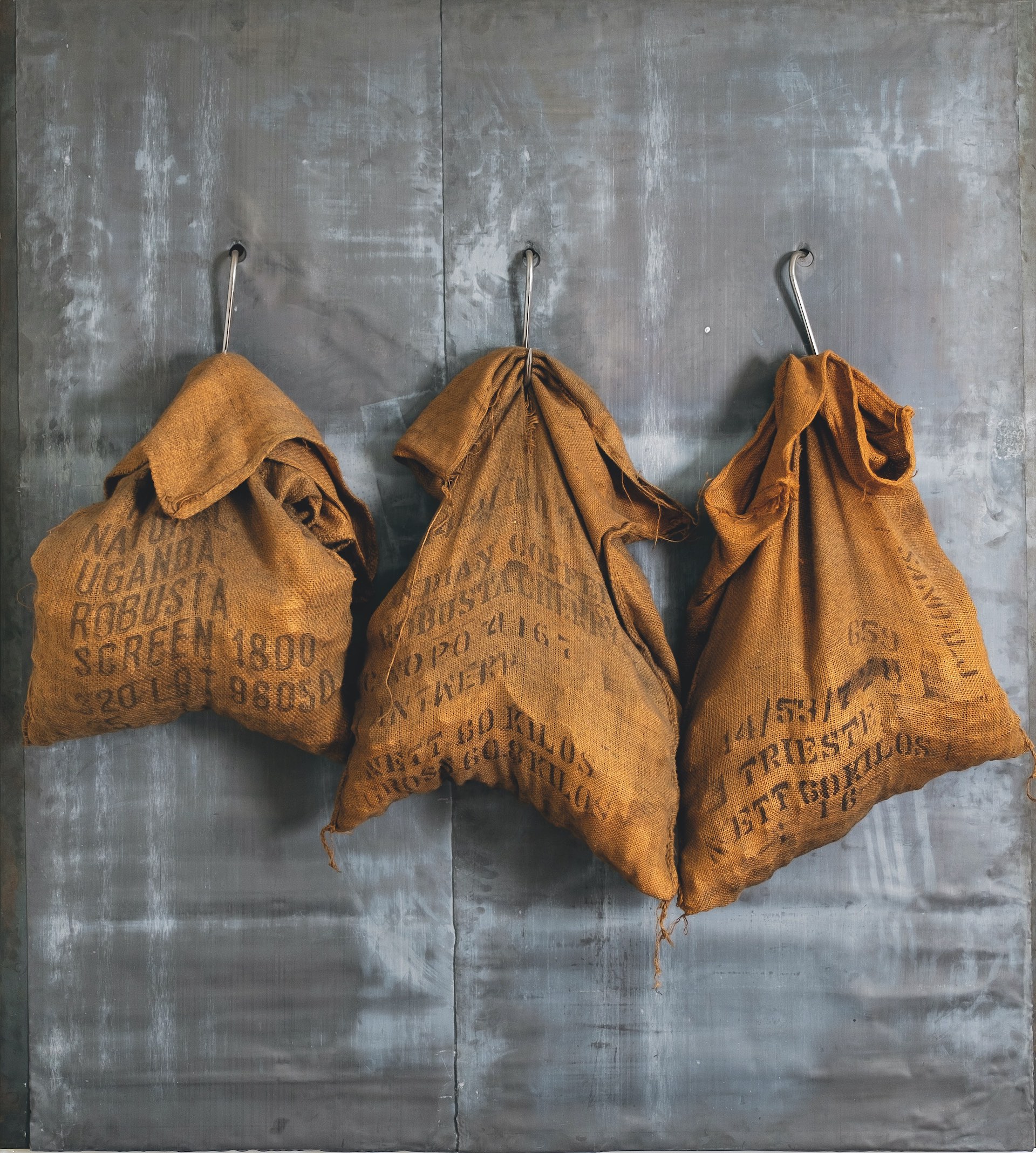 immagine per Jannis Kounellis, Senza titolo, 2000, lastra di ferro, fogli di piombo, ganci, sacchi di juta con carbone, 200 x 180 cm