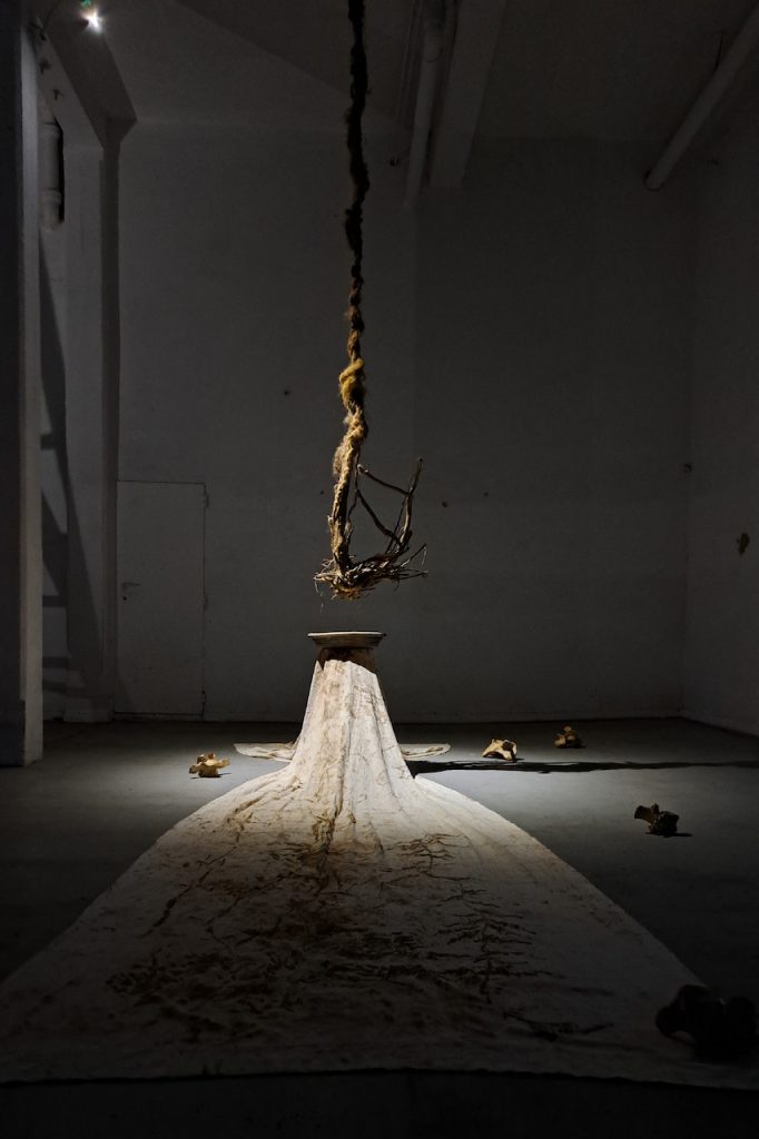immagine per Caterina Sammartino, Là dicono che non si muore, 2023 colori naturali su cotone, pigmento dorato, terracotta, carbone, acqua, radici, canapa, ossa animali; dimensioni variabili Installation view, ExGarage, Roma, 2023