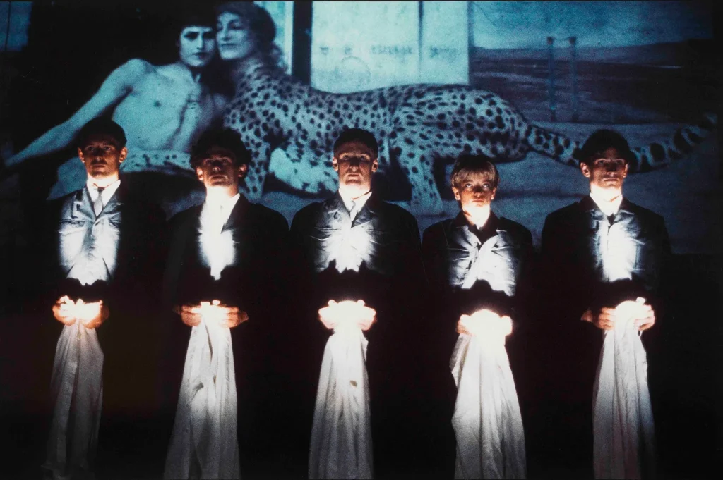 immagine per Una scena di Troubleyn/Jan Fabre, Il potere delle follie teatrali, 1984, con la proiezione sullo sfondo del quadro di Fernand Khnopff, Le carezze, 1896 (https://www.troubleyn.be/eng/performances/the-power-of-theatrical-madness). ©Patrick T. Sellitto