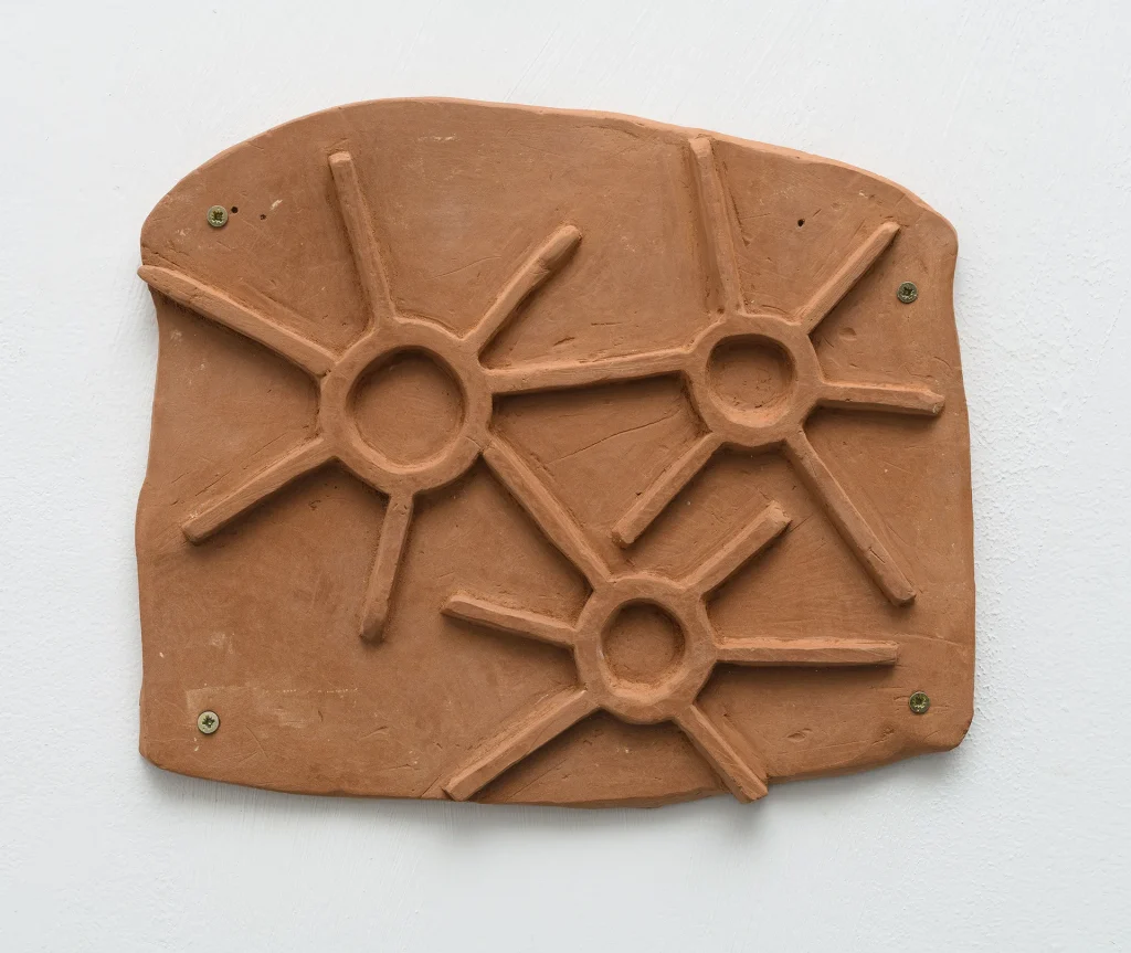 immagine per Maja Escher, trés sóis I – three suns I, 2026, argilla rossa/red clay, 23,5 x 20 x 1 cm. Ph. Giorgio Benni Courtesy l’Artista e Monitor Rome|Lisbon|Pereto(AQ)