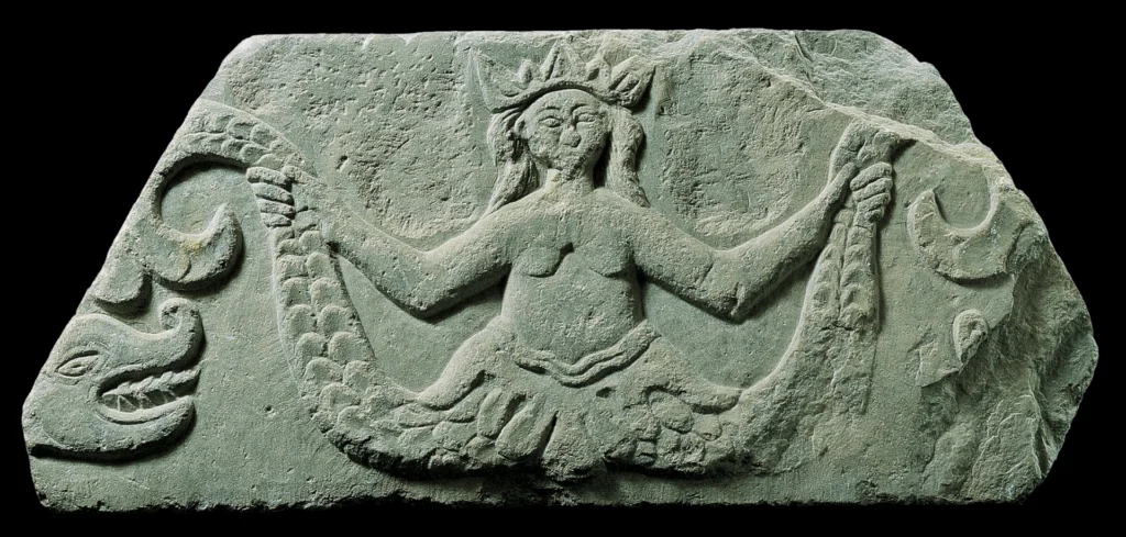 immagine per Fragment of epistyle of a marble tempon-screen with relief decoration of a mermaid with two tails between dragons. Cyclades, 17th – 18th c. Gift of Dionyssis Fotopoulos Benaki Museum, inv. no. ΓΕ 29066