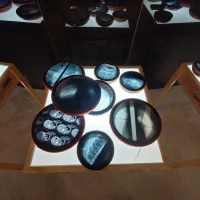 immagine per Amir Zainorin, Rhythm of Identity, 2024, Wood, x-rays, textile and lightbox. 30 pieces of frame drums in various sizes